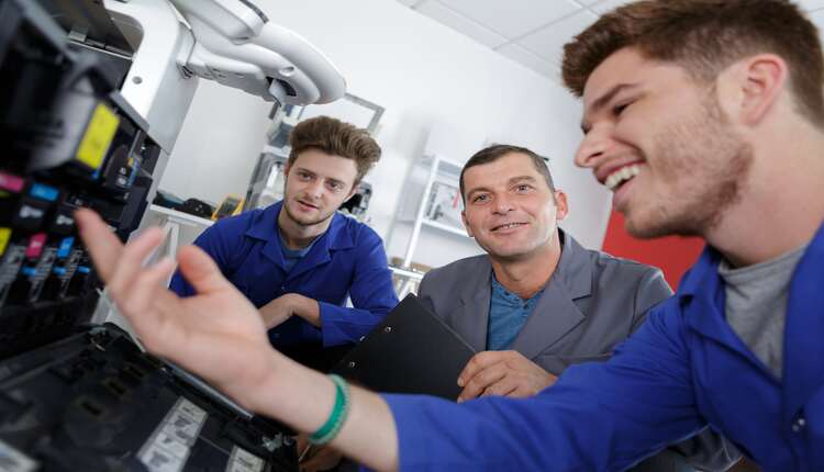 Equipe de réparation rechargeant des cartouches d'encre
